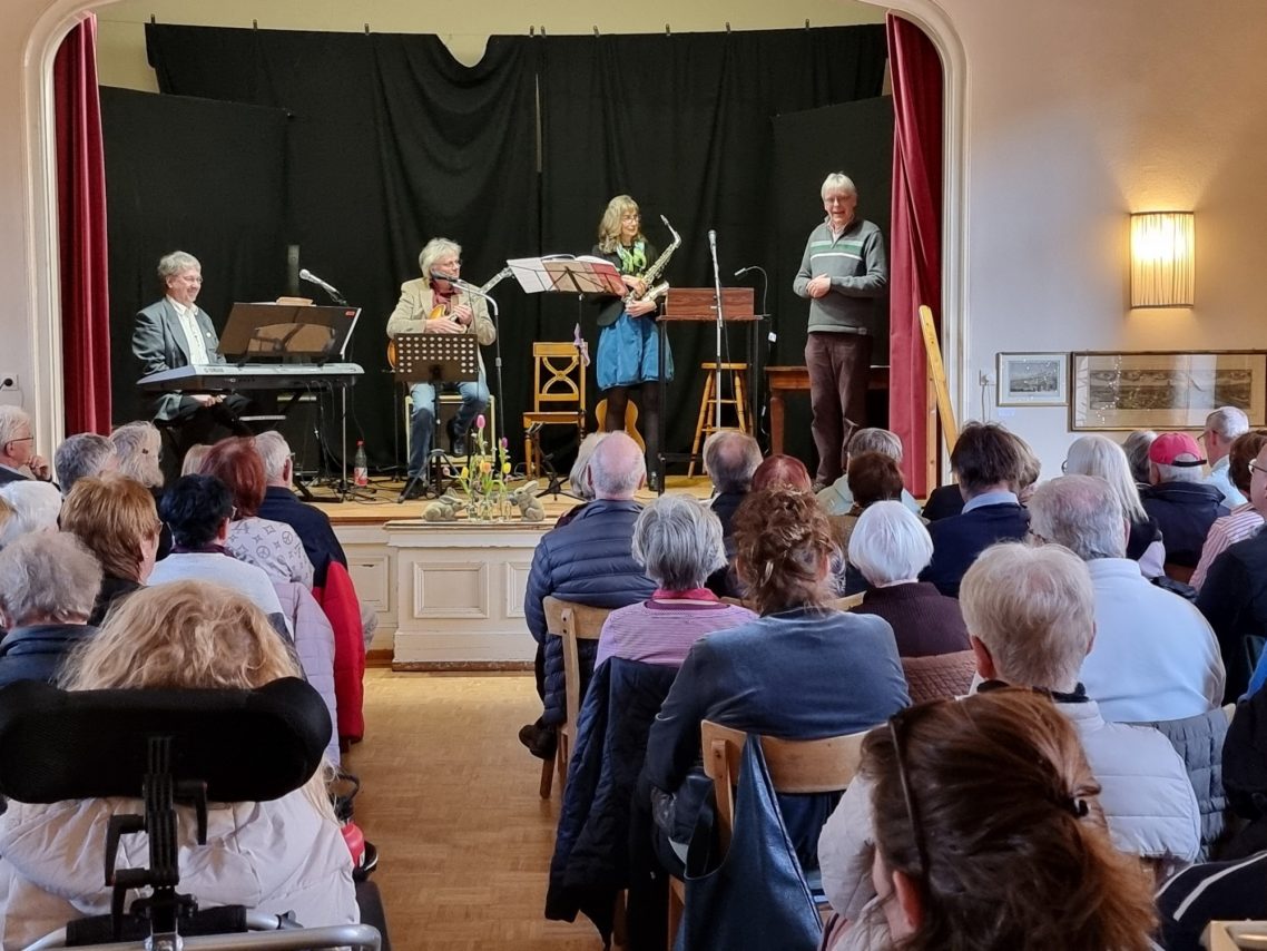 Soirée im Haus Burggarten Musikaufführung auf der Bühne mit Publikum, Pianist und Saxophon in Aktion.